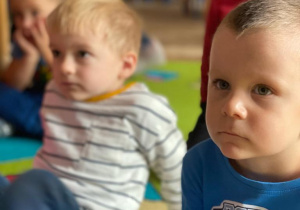 Chłopcy siedzą na dywanie