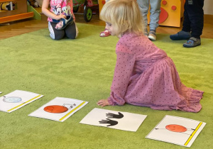 dziewczynka wykonuje ćwiczenie, które widzi na obrazku