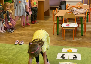 dziewczynka wykonuje ćwiczenie, które widzi na obrazku