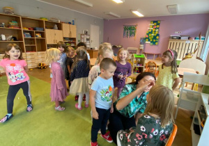 nauczycielka maluje dzieciom kropki na policzkach