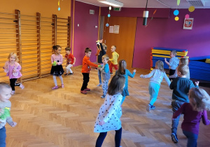 Dzieci biegają po dużej sali
