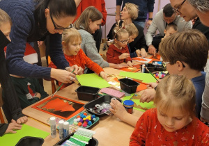 Dzieci i rodzice wykonują pracę plastyczną