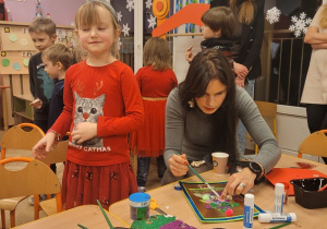 Dziewczynka z mamą wykonuja pracę plastyczną