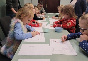dzieci rysuja list do Swiętego Mikołaja