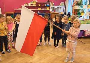 dziewczynka trzyma flagę Polski