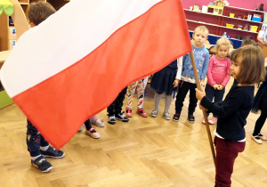dziewczynka trzyma flagę Polski