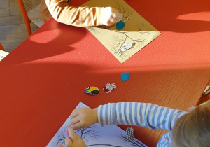 Dzieci naklejają materiały na kontury ptaków