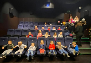 Dzieci siedzą w sali kinowej