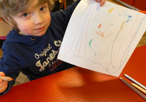 Chłopiec pokazuje swój rysunek