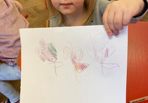Dziewczynka prezentuje swój rysunek