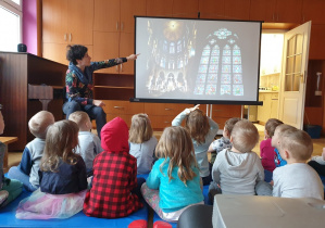 Dzieci oglądają zdjęcie przedstawiające witraże w kościele