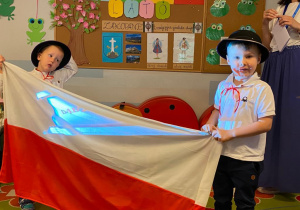 Chłopcy trzymają flagę Polski