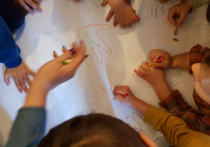 Dzieci odrysowują swoje dłonie na kartonie