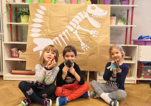 dzieci przy plakacie dinozaura