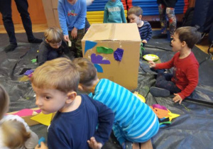 Dzieci wykonują rzeźbę z kartonu i skrawków materiału.