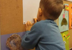 Dziecko prezentuje, jak narysować choinkę.