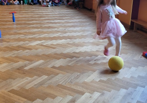 Dziewczynka biegnie z piłką