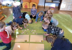 Dzieci siedzą na dywanie i opisuja emocje