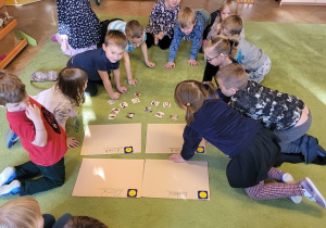 Dzieci siedzą na dywanie i opisuja emocje