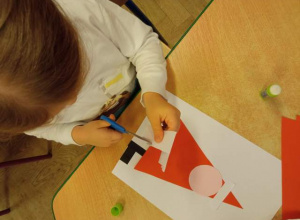 Dziecko wykonuje pracę plastyczną "Św. Mikołaj"