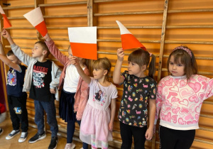 Dzieci z flagami podczas wykonywania hymnu