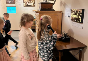 Dzieci korzystają z starego telefonu z tarczą