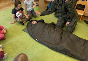 Dziecko w śpiworze żołnierskim