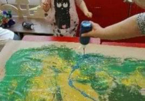 Nauczycielka pomaga przy malowaniu