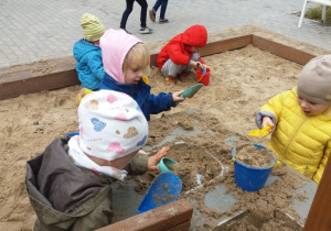 Dzieci bawiące się w piaskownicy. 