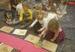 Dzieci odbijają liście na płachcie