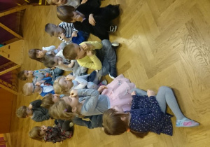 Dzieci siedzą na podłodze